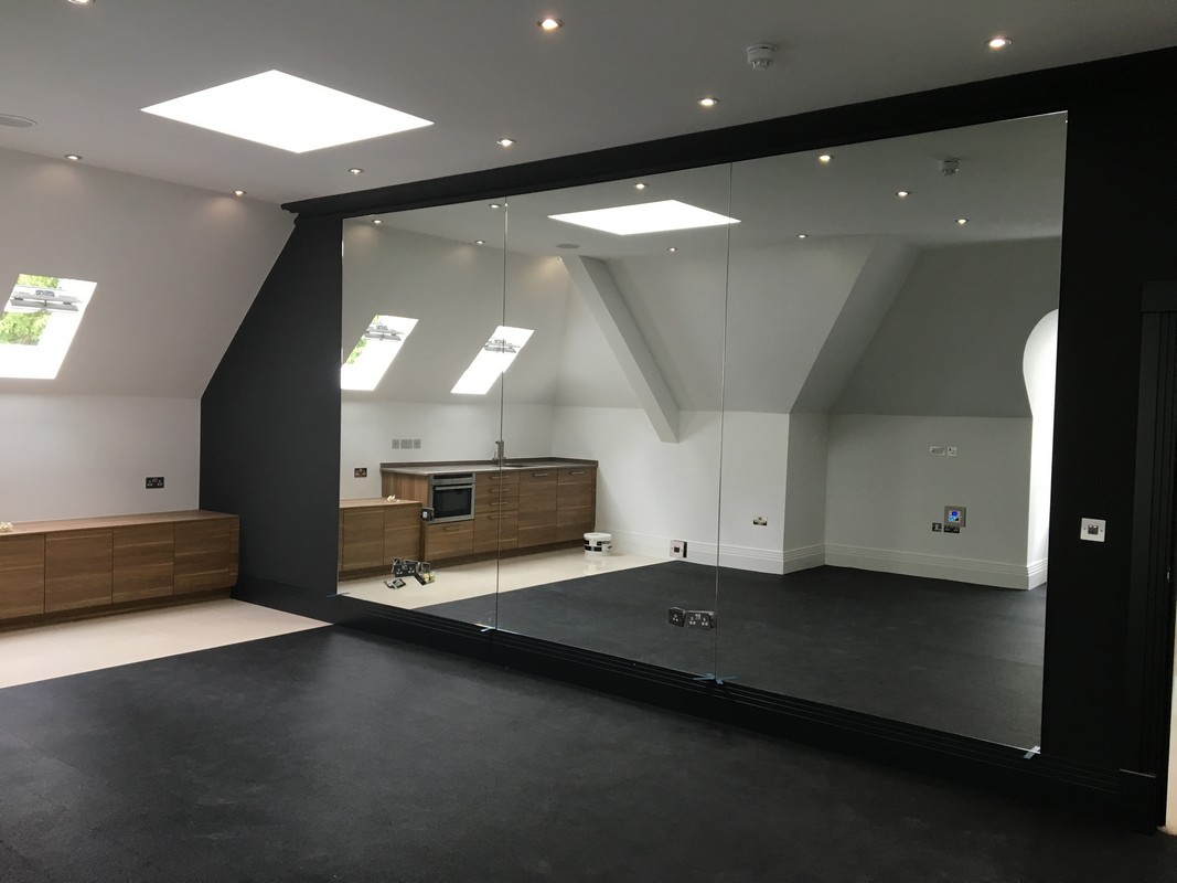 Frameless glass wall dividing loft conversion in Nine Elms